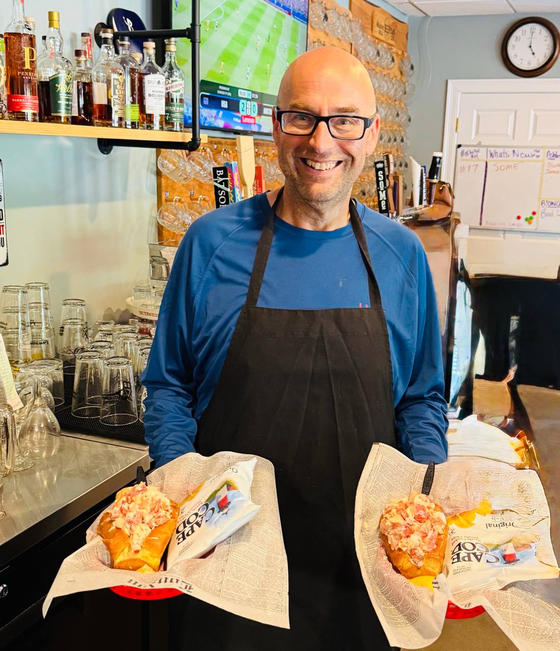 Dave at the counter holding two lobster rolls